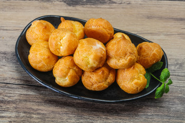 Sweet tasty profiteroles heap in the bowl