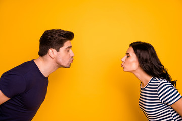 Close-up profile side view portrait of his he her she nice attractive gentle tender affectionate cheerful cheery married spouses kissing closed eyes isolated on bright vivid shine yellow background