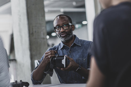 African American male game designer leading a meeting