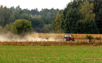 The tractor works on a dry field.