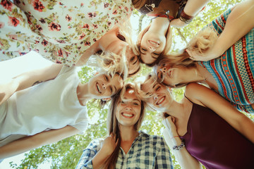 Different and happy in their bodies. Young women smiling, talking, walking and having fun together outdoors on sunny summer's day at park. Girl power, feminism, women's rights, friendship concept.