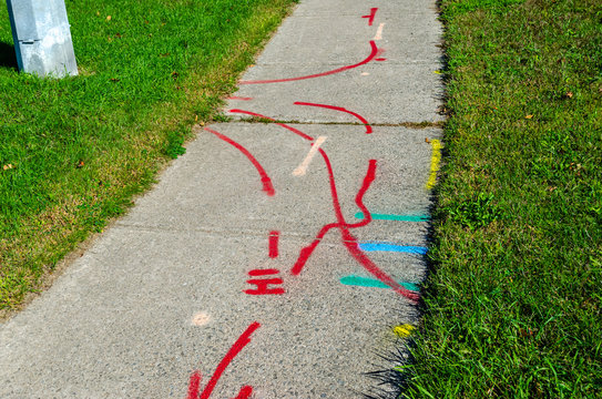 Pattern of hydro, water and gas line markings on a sidewalk