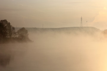 Fototapeta na wymiar misty dawn on the river overlooking the island trees