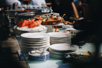 Beautifully decorated catering banquet table with different food snacks and appetizers with sandwich, caviar, fresh fruits on corporate christmas birthday party event or wedding celebration