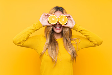 Young blonde woman wearing orange slices as glasses