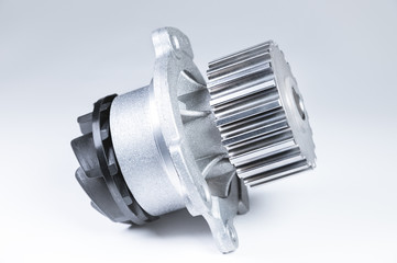 New metal automobile pump for cooling an engine water pump on a gray background with a gradient. The concept of new spare parts for the car engine