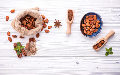 Cocoa powder and cacao beans on wooden background.