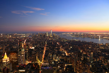 Obraz premium Aerial view of New York City, Lower Manhattan skyline illuminated at sunset, USA