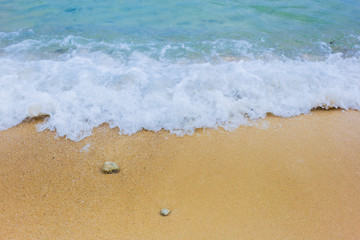 Fototapeta na wymiar Soft waves with blue sea on golden sand.