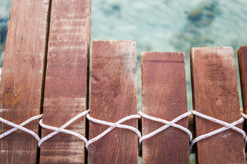 Fototapeta premium Wooden bridge and rope tied over the sea