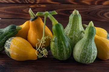 Beautiful, bright vegetables-pumpkins yellow and green on a beautiful natural wooden background.