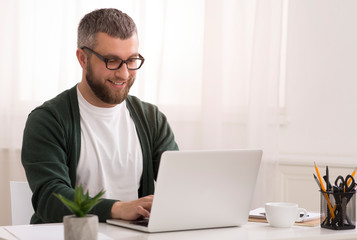 Middle aged man enjoying his job, working from home