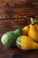 Beautiful, bright vegetables-pumpkins yellow and green on a beautiful natural wooden background.