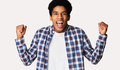 Naklejka premium Black guy screaming Yes and raising clenched fists in the air