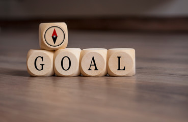 Cubes and dice with words Goal and compass icon on wooden background