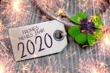 Wooden hang tag with four leaf clover and sparklers and with the german words for happy new year -...