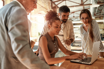 Successful team. Business people looking at the laptop while working together in the modern office