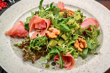 salad with parma ham jamon , tomatoes and arugula