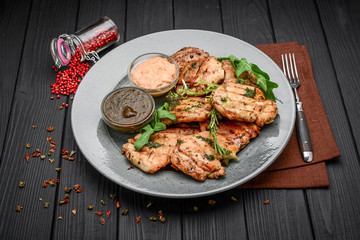 Tasty Grilled chicken fillet and chili peppers on a plate on the table. horizontal view from above