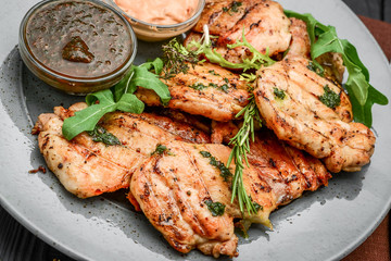 Tasty Grilled chicken fillet and chili peppers on a plate on the table. horizontal view from above