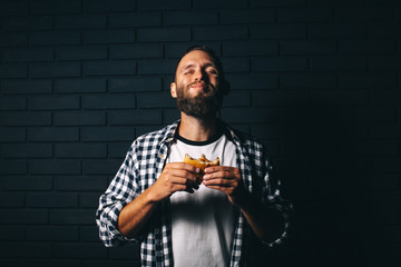 Hungry man with beard eating a hamburger