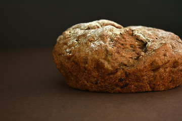 Whole grain rye bread, isolated on dark background. Closeup