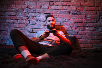Fototapeta premium Emotional guy playing video game at home. Concept of gaming and technology. Relax
