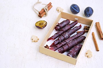 Pastille, handmade natural sweet apple and plum puree, rolled into rolls, in a cardboard box. Healthy desserts. Harvest apples and plums. Thanksgiving Day. Selective focus