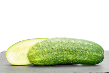 Group of two halves of fresh green pickling cucumber on grey stone isolated on white background