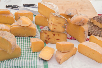 Different sorts of cheese wheels at a market