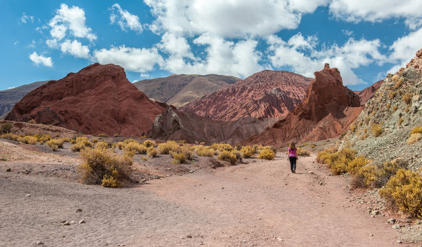 Young woman walking around and taking a picture with her mobile phone in Rainbow Valley in Atacama Desert. Mountains northern from San Pedro de Atacama. Stunning scenery in sunlight at Atacama desert,