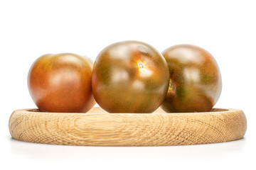 Group of three whole fresh green red tomato on bamboo plate isolated on white background