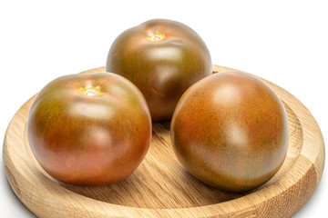 Group of three whole fresh green red tomato on bamboo plate isolated on white background