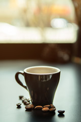 cup of coffee and beans on wooden table