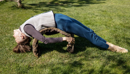 Young woman doing yoga in morning park. Rural yoga