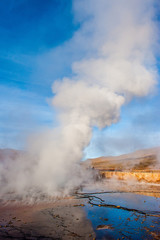 El Tatio, Atacama, Chile. Active geysers comes out of the ground. Hot vapor erupting activity, thick flume of steam. Tourists watching geyser in the Los Géiseres del Tatio area in the Atacama Desert