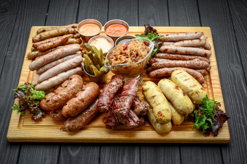 Grilled sausages with glass of beer on a wooden table