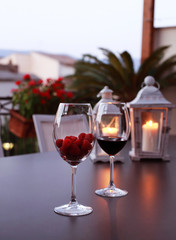 Two glasses of wine on table at the romantic sunset