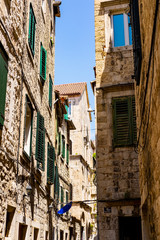 Fototapeta na wymiar Dalmatian stone houses in the narrow street, stone facades, summer holidays in Split, Dalmatia, Croatia 