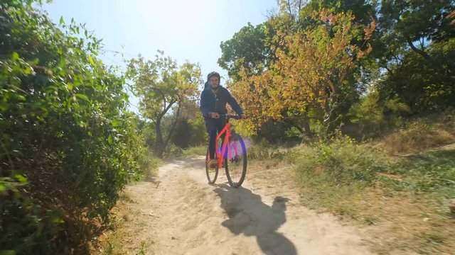 Young male on the bicycle with helmet ride in the forest in sunny day 4K UHD
