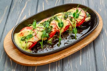 Delicious baked tomatoes stuffed with curd on a wooden table