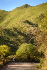 Cerros y montañas con camino y joven caminando