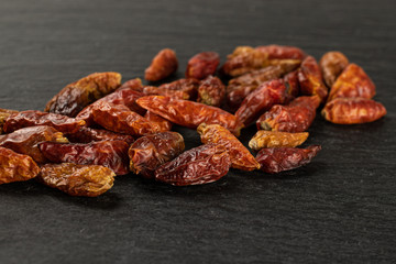 Lot of whole dry red chili pepper peperoncino on grey stone