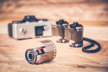 Closeup of a film photography roll with vintage camera. Shallow depth of field. Retro look effect.