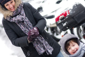 Bataille de boules de neige entre maman et son fils