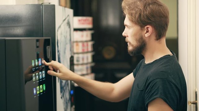 Young Man Buying Coffee Vending Machine