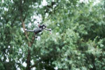 quadrocopter gray color in the sky on a wood background. Aero video photo shooting. Action camera.