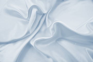 Delicate satin draped fabric of blue color texture for festive backgrounds