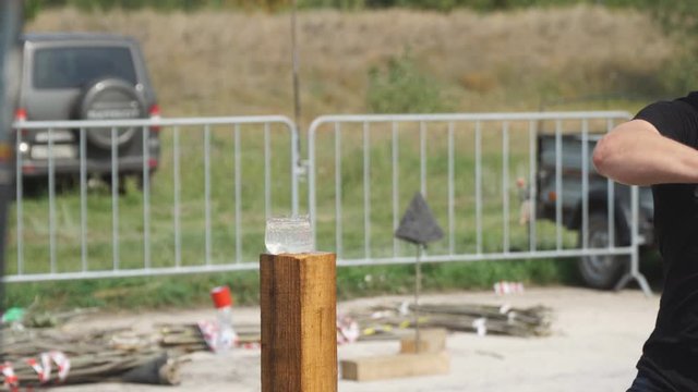 A man cuts a cavalry saber plastic bottle of water