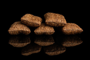 Group of five whole crispy brown cereal pillow isolated on black glass